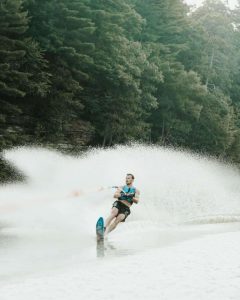 A man ski behind a pontoon boat